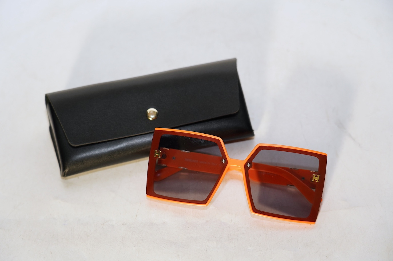 A pair of orange Hermes sunglasses